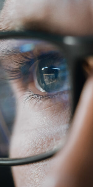 Close-up Portrait of Software Engineer Working on Computer, Line of Code Reflecting in Glasses. Developer Working on Innovative e-Commerce Application using Machine Learning, AI Algorithm, Big Data